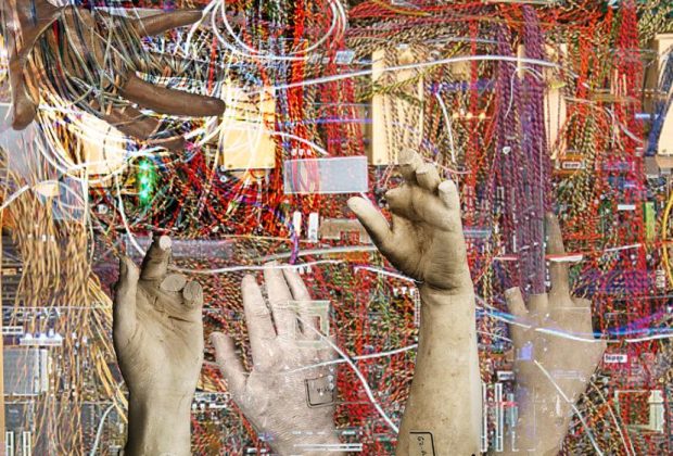 The image depicts a series of stone-like hands, fractured and cracked, reaching out in various directions from a chaotic mass of tangled wires. Some hands display broken fingers, while archival tags on others suggest anonymity and erasure. The juxtaposition of human forms and technological wires evokes themes of labor, exploitation, and the often unseen physical work behind the tech industry.